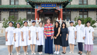 Group of nursing students with Dean Frazier standing in front of building in China.